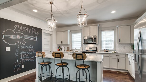 A modern kitchen with white cabinets, a central island with bar stools, a chalkboard wall with a guitar drawing, and a stainless steel refrigerator. - Spring Discounts! Big Yard for Pets! Restaurants!BROADWAY/Downtown 1 ML TOPGOLF! (Nashville)