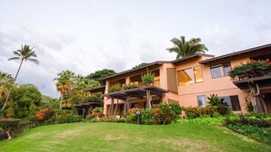 A multi-story building with balconies, surrounded by lush greenery and palm trees. - Wailea Ekahi #45-E Ocean View Beachfront Resort Great Rates, Pool, Near Beach (Wailea)