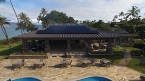 A poolside area with a covered seating area, lounge chairs, and a view of the ocean. - Wailea Ekahi #45-E Ocean View Beachfront Resort Great Rates, Pool, Near Beach (Wailea)