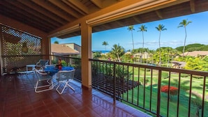 A covered outdoor area with a view of a landscaped garden and palm trees. - Wailea Ekahi #45-E Ocean View Beachfront Resort Great Rates, Pool, Near Beach (Wailea)