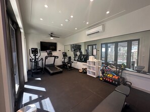 A gym with treadmills, a stationary bike, and a weight rack.