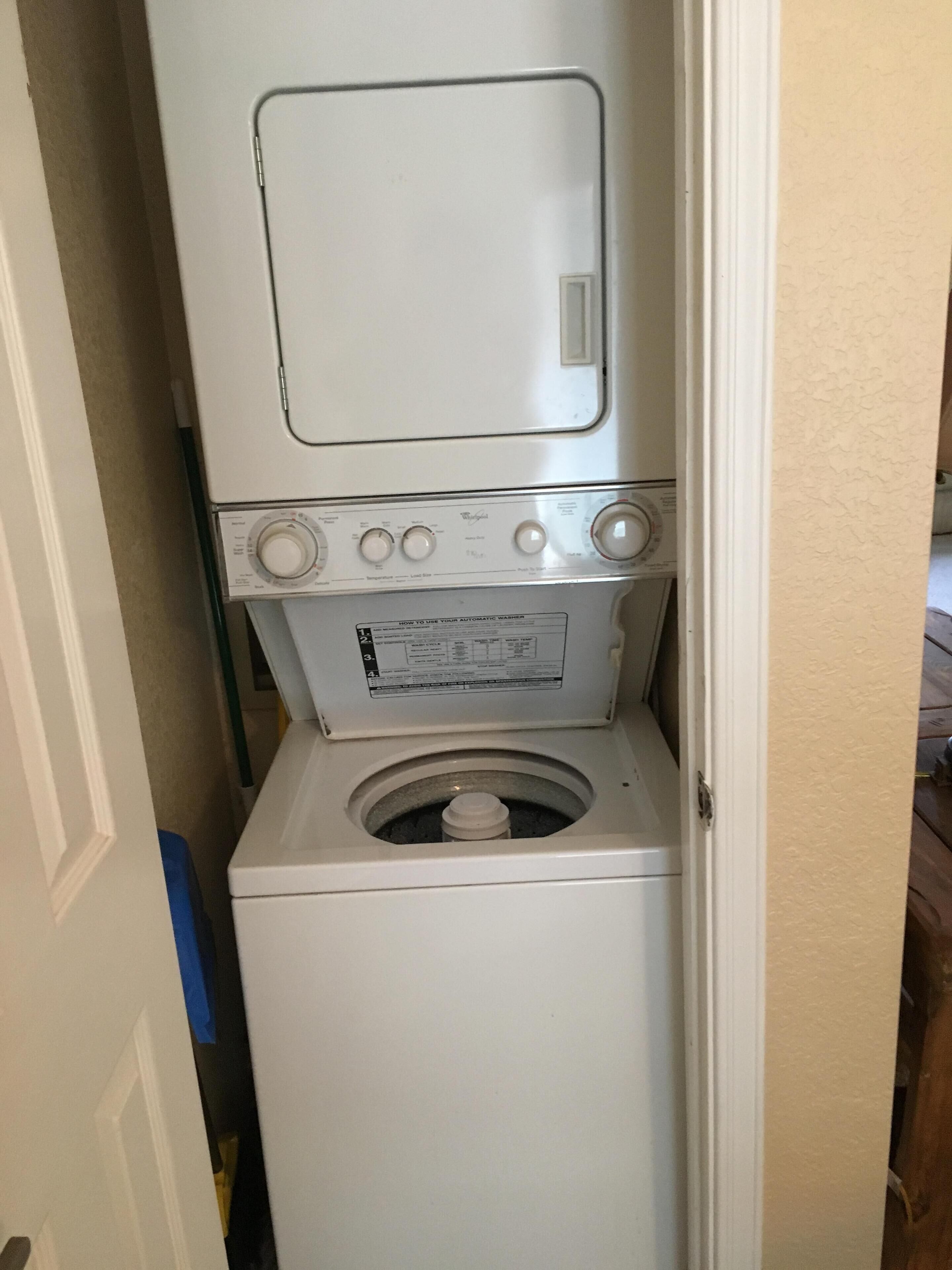A compact washer and dryer unit in a small laundry room.