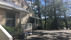 A single-story house with a porch, surrounded by trees. - Awesome condo, great location, quiet area, completely updated, with wifi.& AC (Ruidoso)