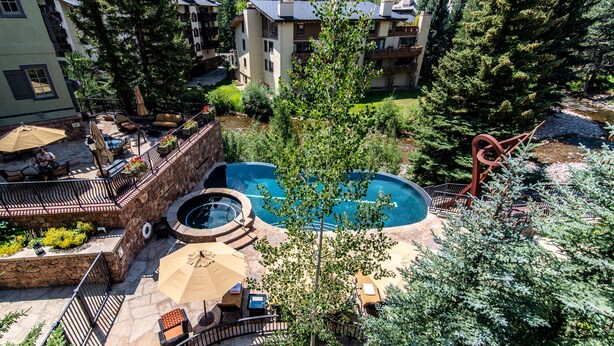 A rooftop pool area with a hot tub, lounge chairs, and a view of surrounding buildings. - One Willow Bridge Road - 3-room residence (Vail)
