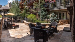 An outdoor patio area with wicker furniture and a stone floor. - One Willow Bridge Road - 3-room residence (Vail)