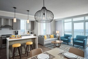 Habitación de hotel moderna con cocina, comedor y un conjunto de sofás.