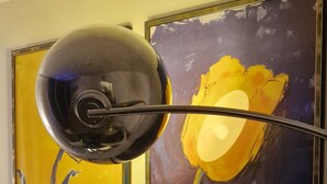 Zwei gerahmte Bilder an einer Wand, eines zeigt eine gelbe Blume und das andere ein blaues abstraktes Design.