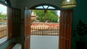Una habitación con vista a un tejado rojo y un árbol.