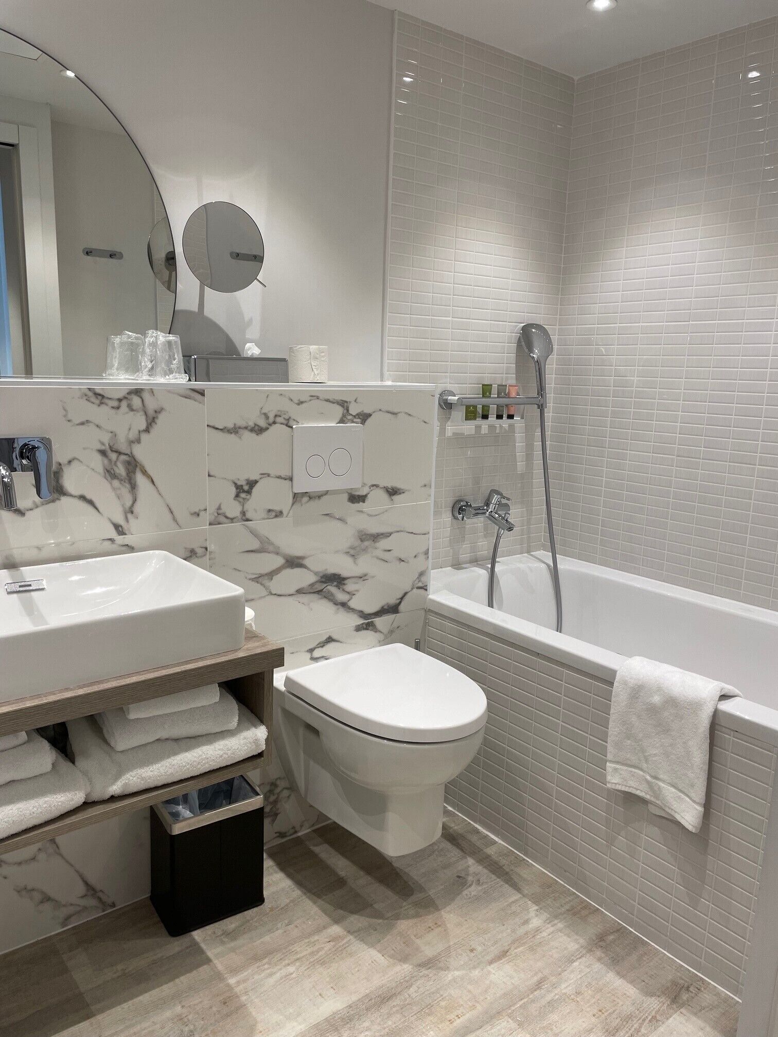 Un baño moderno con tocador de mármol, inodoro, bañera y ducha.