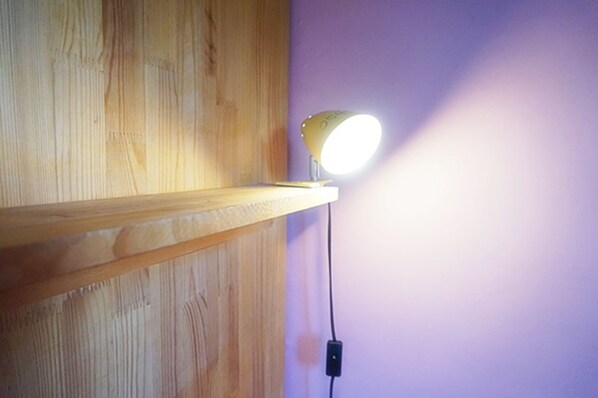 A wooden shelf with a lamp on it.