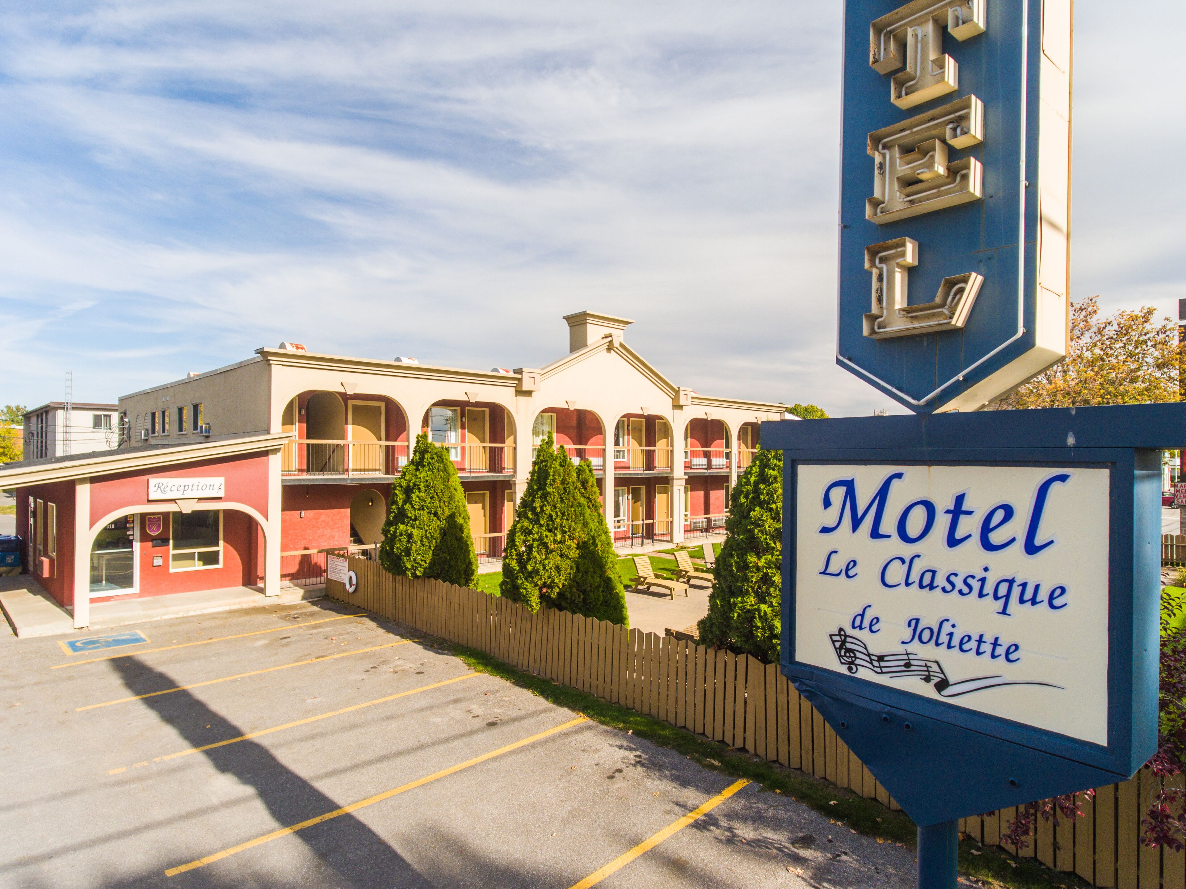 A motel with a classic design, featuring a reception area and multiple balconies.