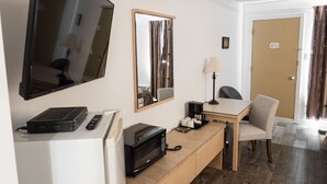 A hotel room with a flat-screen TV, a microwave, a coffee maker, a desk, and a chair. - Motel LeClassique (Saint-Charles-Borromée)