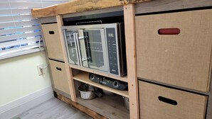 Une cuisine avec des meubles en bois, un four encastré et un évier.