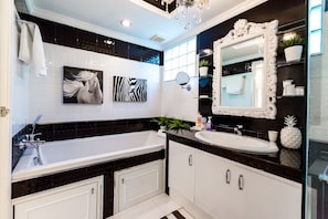 Bathtub, rainfall showerhead, hair dryer, towels