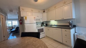 A compact kitchen with white cabinets, a refrigerator, a microwave, and a coffee maker. - Close to beach! Spacious -Condo B (Ocean City)