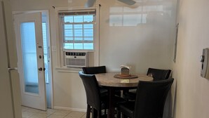 A dining area with a table and chairs, a ceiling fan, a window with blinds, and a door leading to another room. - Close to beach! Spacious -Condo B (Ocean City)