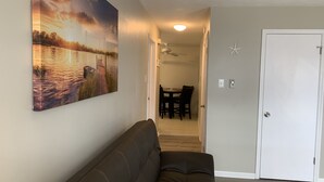 A living room with a dark brown sofa, a dining area with a table and chairs, and a door with a star decoration. - Close to beach! Spacious -Condo B (Ocean City)