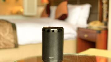 A cylindrical black object on a table in a hotel room.