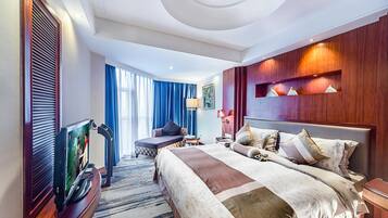 Habitación de hotel moderna con una cama grande, televisión, zona de estar y vistas al exterior.
