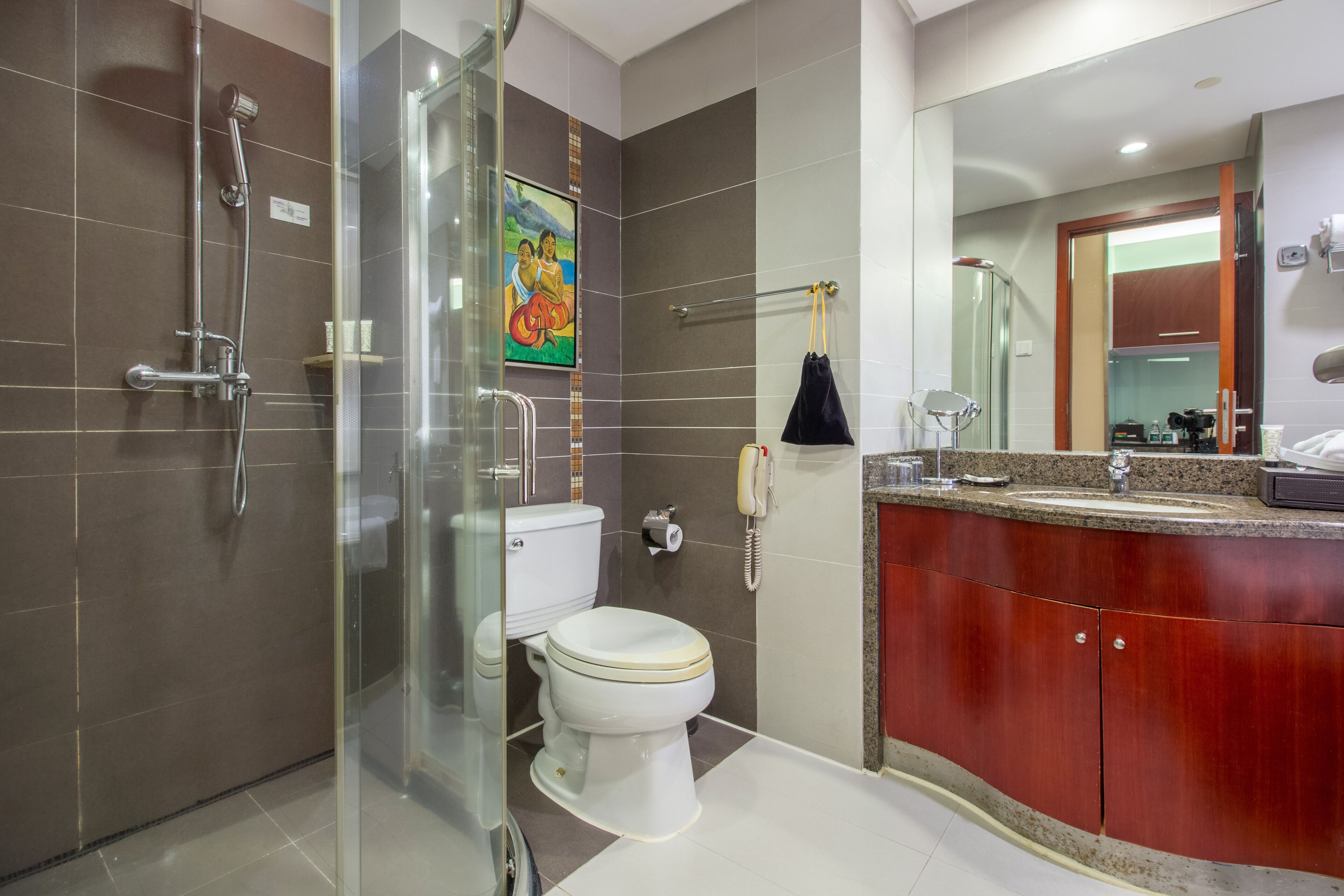 A modern bathroom with a glass-enclosed shower, a toilet, and a vanity with a sink and mirror.