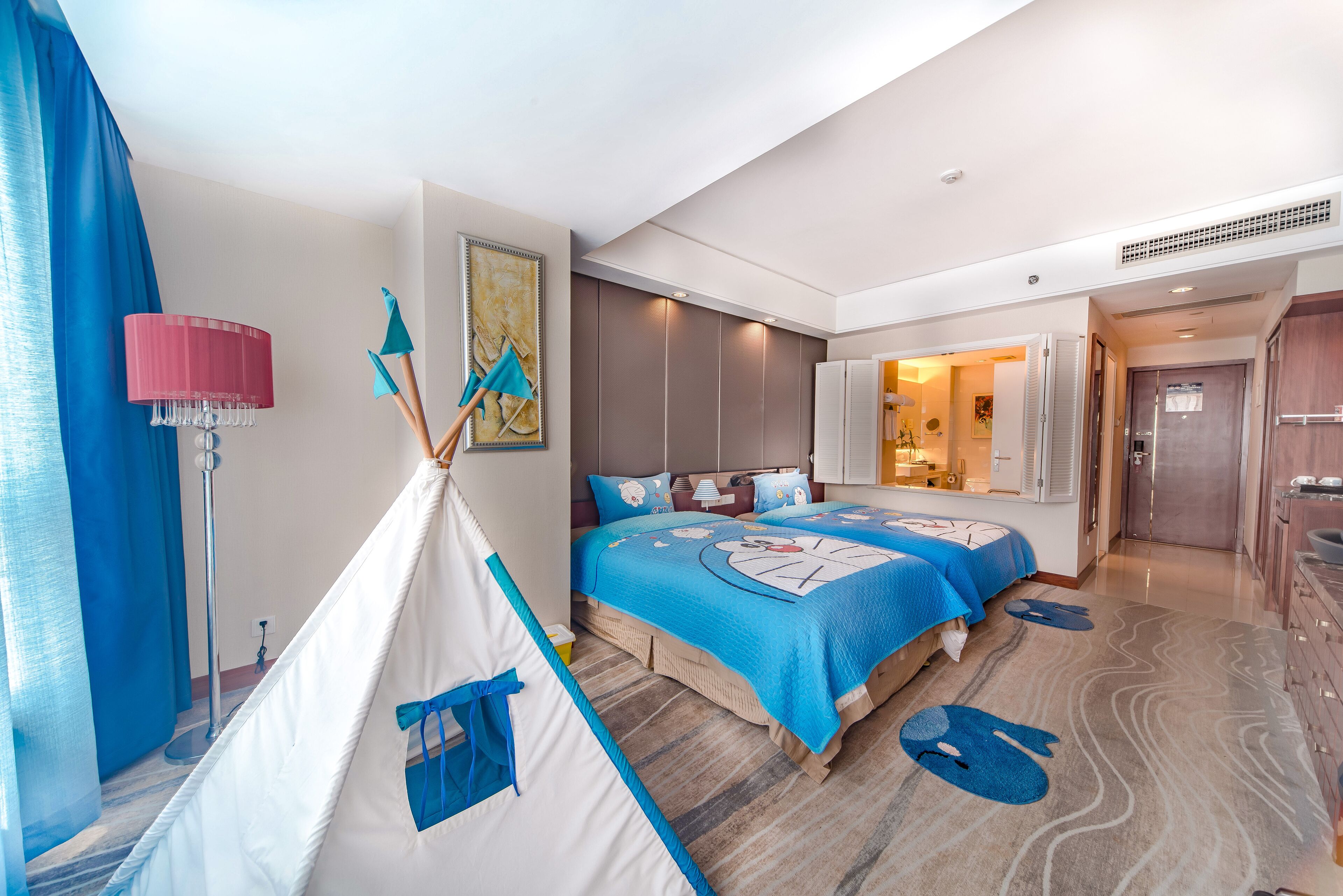 A modern hotel room with a large bed, a tent-like structure, and a bathroom visible through an open door.