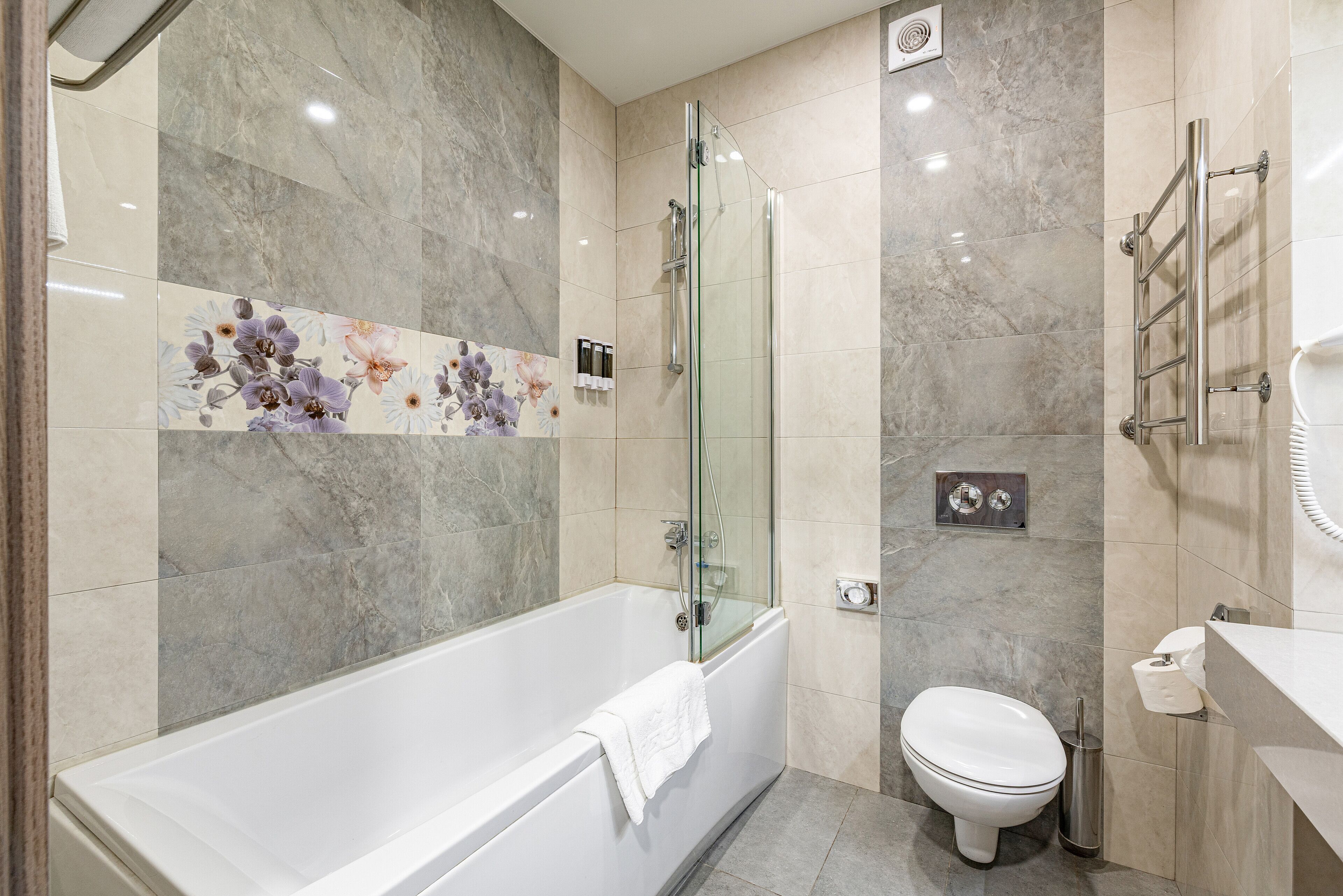 Une salle de bain moderne avec une douche à parois de verre, une baignoire blanche et des toilettes.