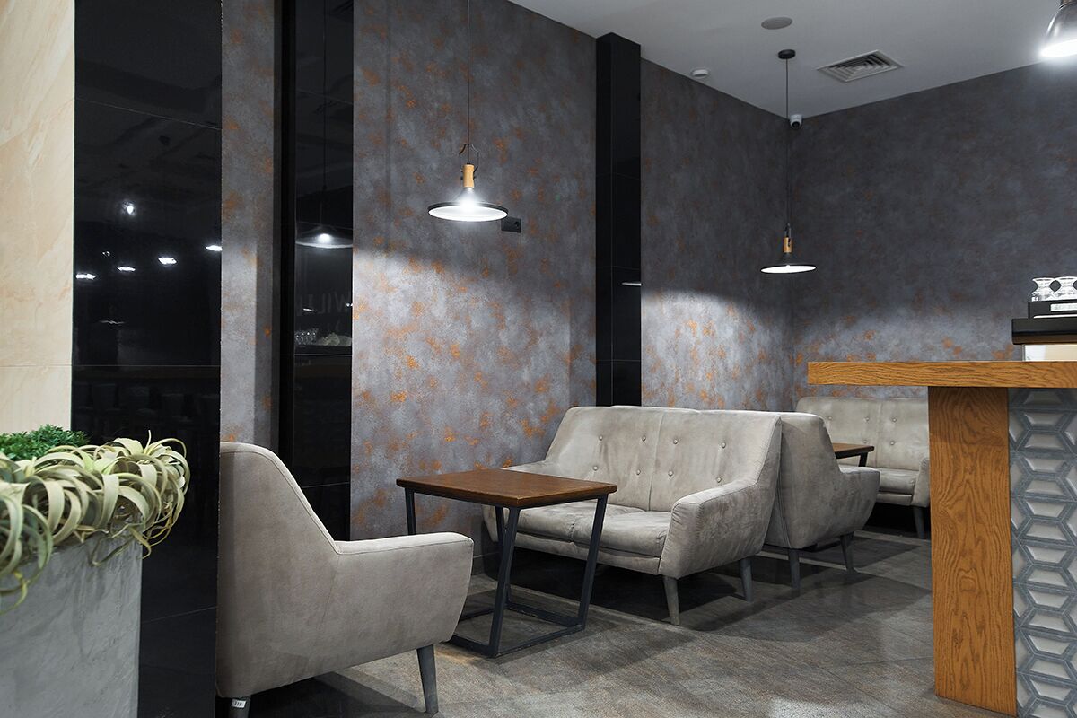 Un interior moderno con un sofá, una mesa de madera e iluminación colgante.