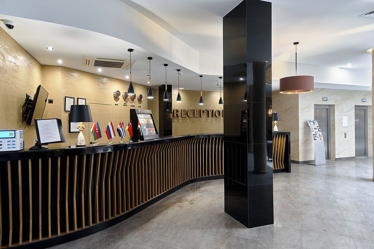 Un comptoir d’accueil orné de drapeaux, un espace d’accueil et un aménagement intérieur moderne.