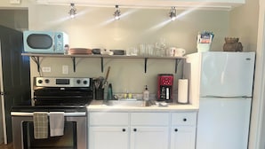 A compact kitchen with a microwave, stove, oven, coffee maker, and refrigerator. - 1 bed/1 bath, 1.5 blocks to beach/town, dog friendly (Union Pier)