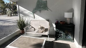 Una stanza luminosa con ventilatore a soffitto, un divano, un tavolino, un armadio e una scultura di pesce a parete.