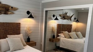 Una camera da letto con un letto, comodini, uno specchio e una ventola a soffitto.