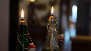 Two glass bottles with metal clasps and a lit candle inside each.