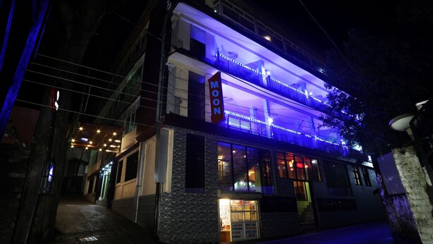 Un edificio de dos pisos con un cartel que dice "MOON" y un escaparate con un cartel que dice "MOON MARKET".