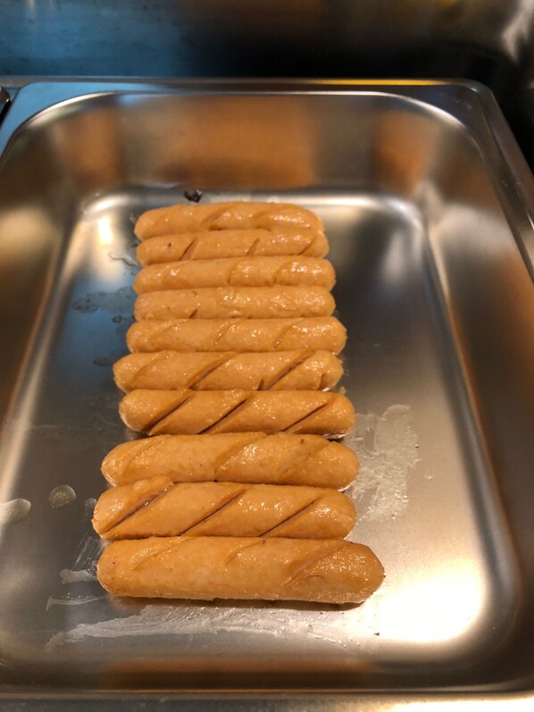 A stainless steel tray with several golden-brown pastries arranged in a row. - Hotel Rose Hill (Yangon)