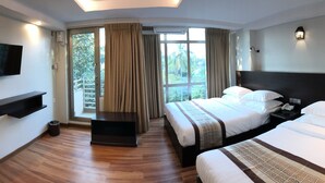 A hotel room with two beds, a TV, a desk, and a window with curtains. - Hotel Rose Hill (Yangon)
