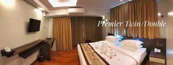 Habitación doble o twin de categoría superior con cama, mesitas de noche, televisor y escritorio con silla.
