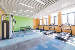 A gym with treadmills, elliptical machines, and a weight bench. - Atour Hotel Xiang cheng Suzhou (Suzhou)