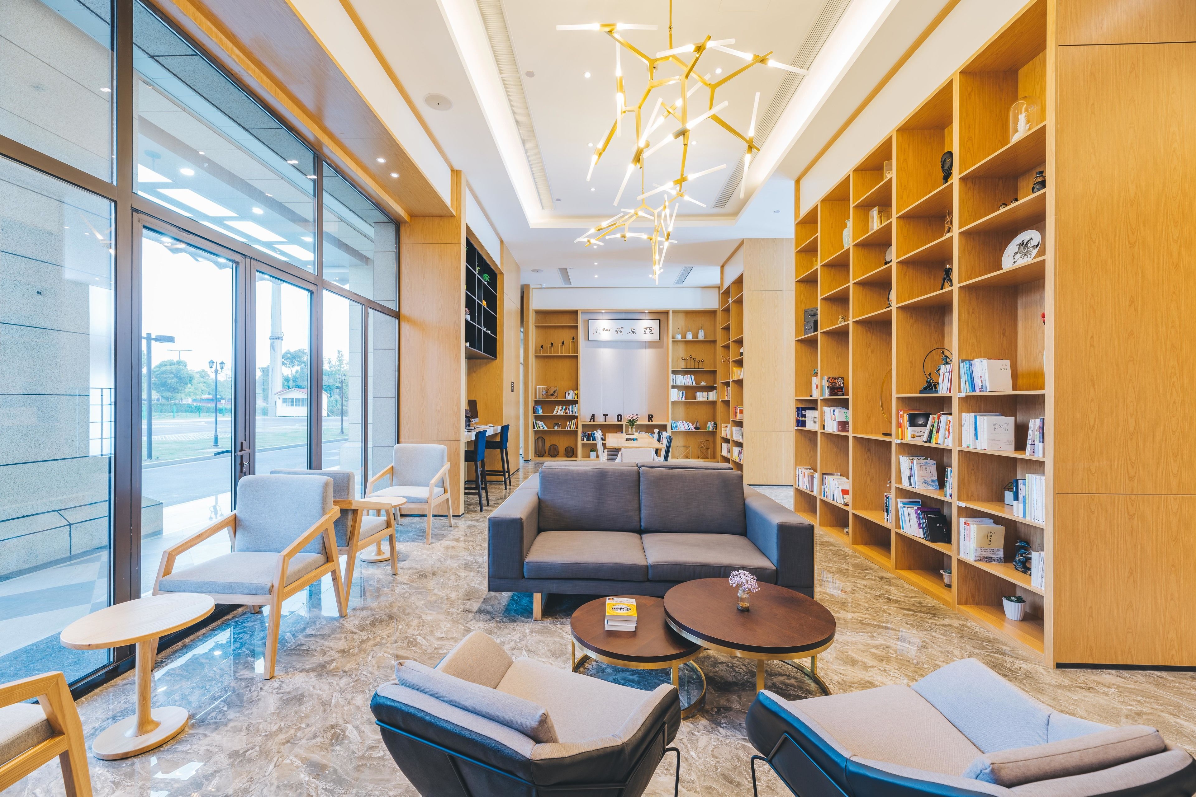 Una biblioteca moderna con un sofá, sillas y estanterías.