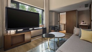 Una sala de estar moderna con un televisor de pantalla plana grande, una mesa de centro redonda y un sofá.