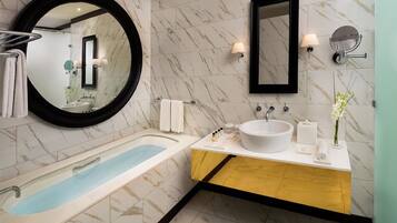 A modern bathroom with a freestanding bathtub, a large mirror, and a vanity with a sink and mirror.