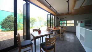 Een moderne keuken met witte kasten, een inbouwoven en een groot raam met uitzicht op een tuin.