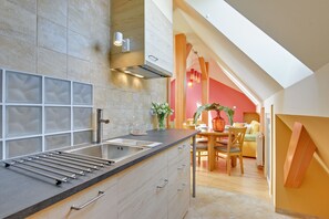 A modern kitchen with a large island, built-in appliances, and a dining area with a table and chairs.