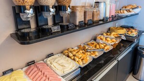 Un bufé con diversos alimentos y utensilios para servir.