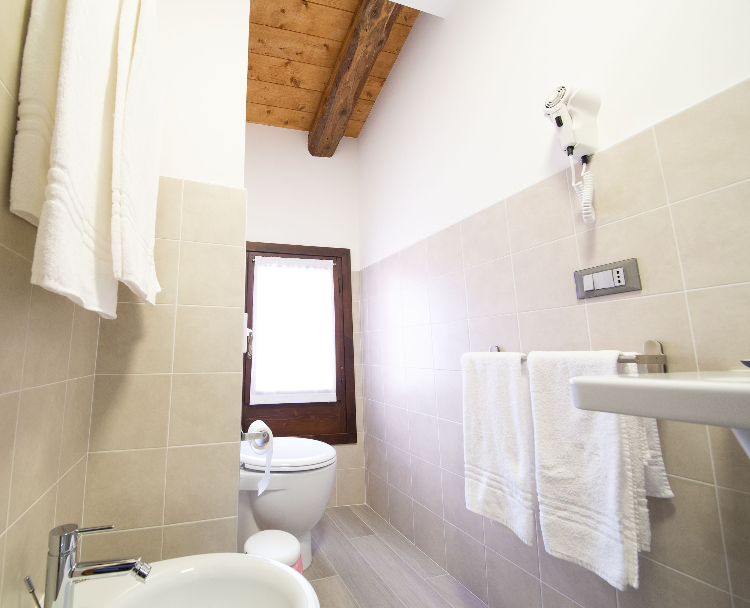 A bathroom with a toilet, sink, and towel rack.
