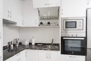 Een koelkast met diepvriezer, een microgolfoven, een oven