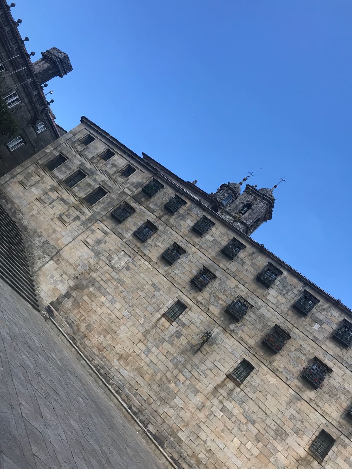 Un edificio histórico con una torre destacada y numerosas ventanas.