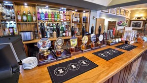 Eine Bar mit einer Auswahl an Spirituosenflaschen und mehreren Zapfhähnen für Bier.