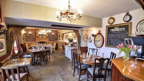 Ein gemütliches Restaurant mit Holzmöbeln, einer Chandelüster und einer Kreidetafel-Speisekarte.