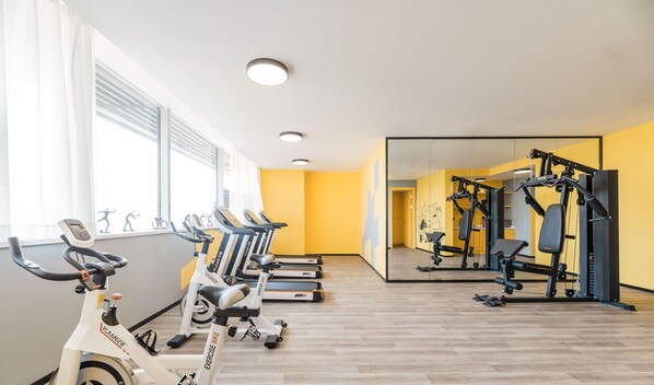 A gym with exercise bikes, treadmills, and weight machines. - Atour Hotel Hunan Road Nanjing (Nanjing)