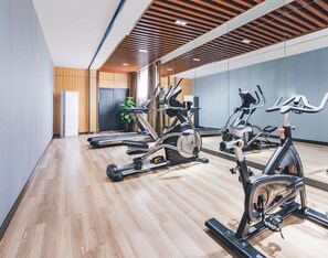 A modern gym with stationary bikes, a treadmill, and a mirrored wall. - Atour Hotel Lukou Airport Nanjing (Nanjing)